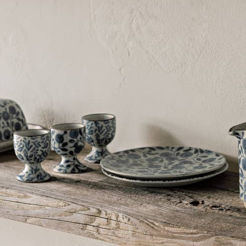 Set of ceramic dishes with blue floral patterns on wooden shelves.