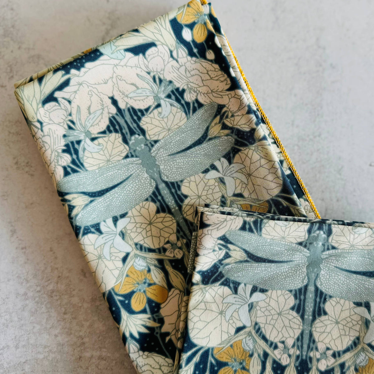 Two fabric items with dragonfly pattern on a light gray background